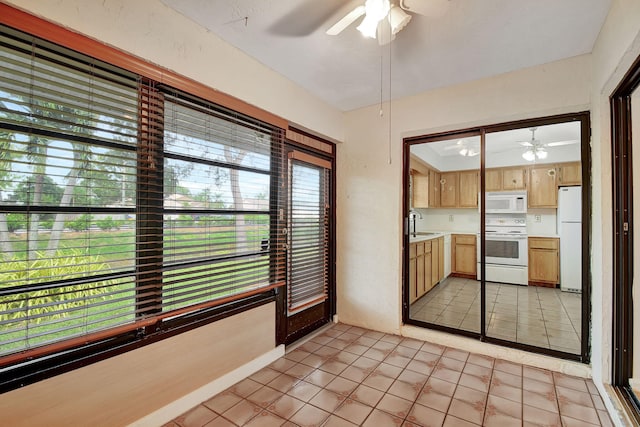 interior space with white appliances, ceiling fan, a healthy amount of sunlight, and sink