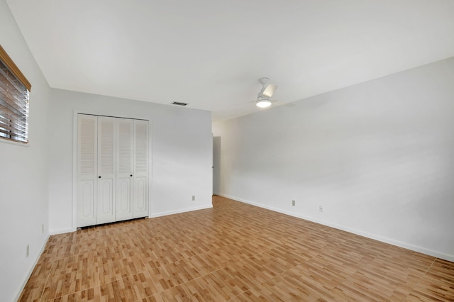 unfurnished bedroom with ceiling fan, a closet, and light hardwood / wood-style flooring