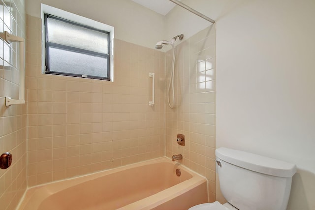 bathroom with toilet and tiled shower / bath