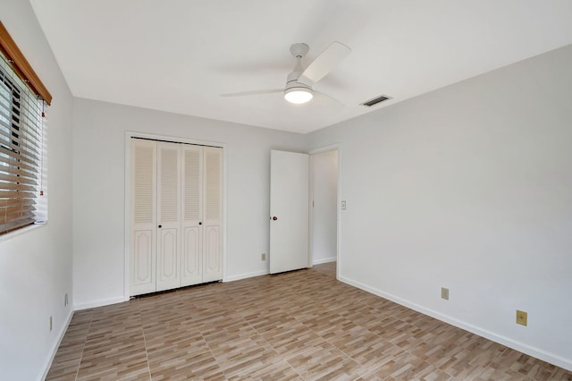 unfurnished bedroom with ceiling fan and a closet