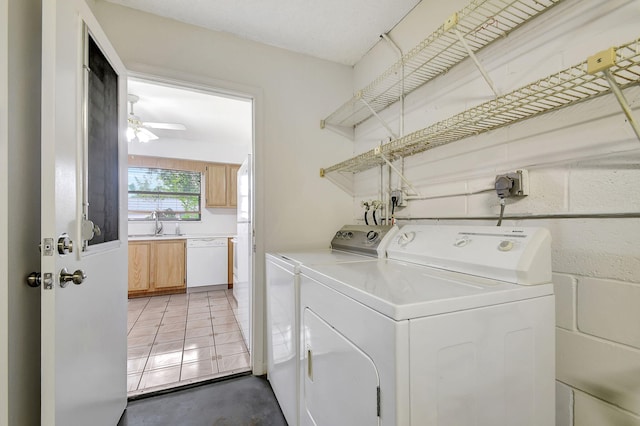 clothes washing area featuring ceiling fan, sink, and washer and dryer