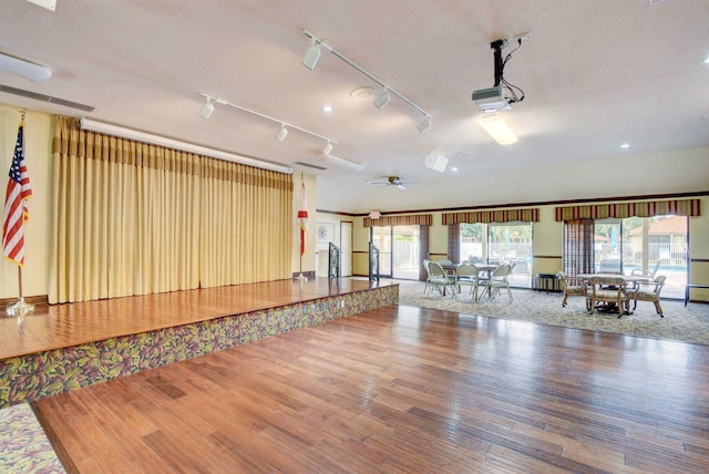 workout area with hardwood / wood-style floors, rail lighting, a textured ceiling, and ceiling fan