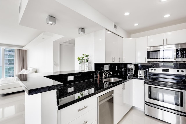 1000 W Ave Unit 502, Miami Beach, FL 33139 - kitchen featuring stainless steel appliances, a peninsula, recessed lighting, white cabinetry, and open floor plan