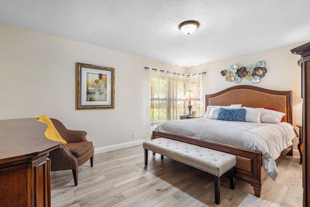 bedroom featuring a textured ceiling and light hardwood / wood-style flooring