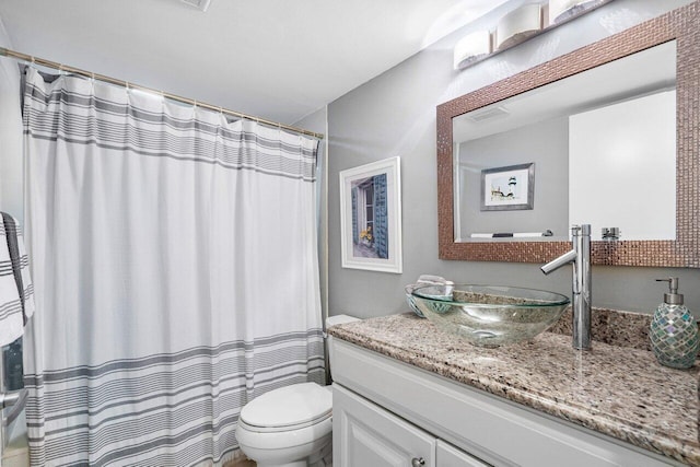 bathroom with toilet, vanity, and curtained shower