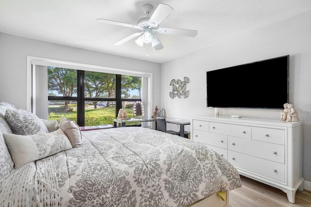 bedroom with a textured ceiling, ceiling fan, and light hardwood / wood-style floors