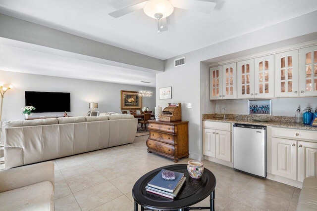 kitchen with white cabinets, light tile patterned floors, sink, and stainless steel refrigerator