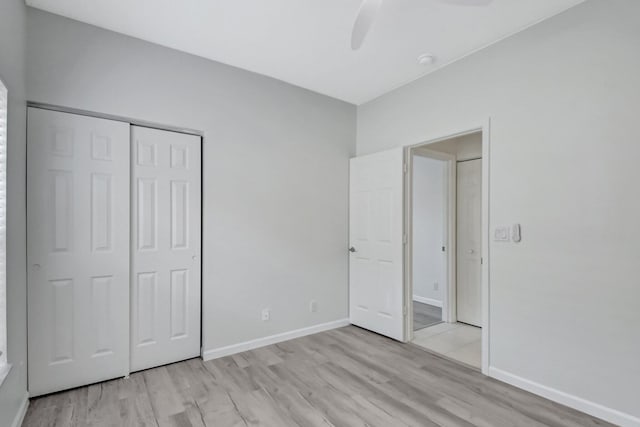 unfurnished bedroom featuring ceiling fan, a closet, and light hardwood / wood-style floors