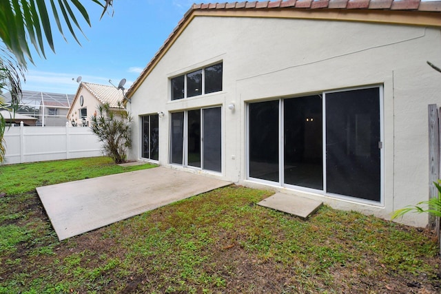 back of house featuring a lawn and a patio