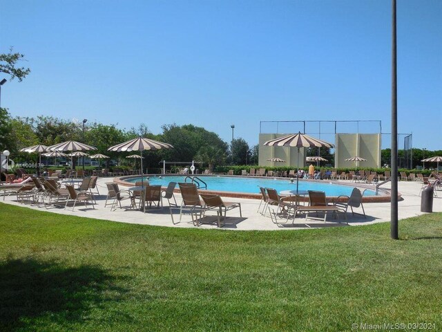 view of pool with a patio and a yard