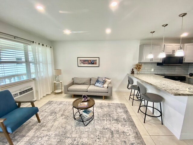 living room featuring light tile patterned floors and a wall mounted AC