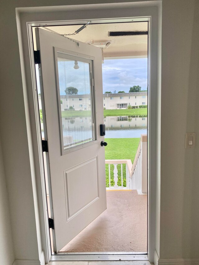 entryway featuring a water view and carpet flooring