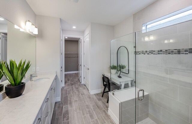 bathroom featuring walk in shower and vanity