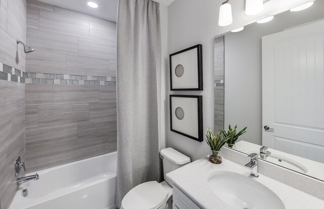 full bathroom featuring shower / bath combo, vanity, and toilet