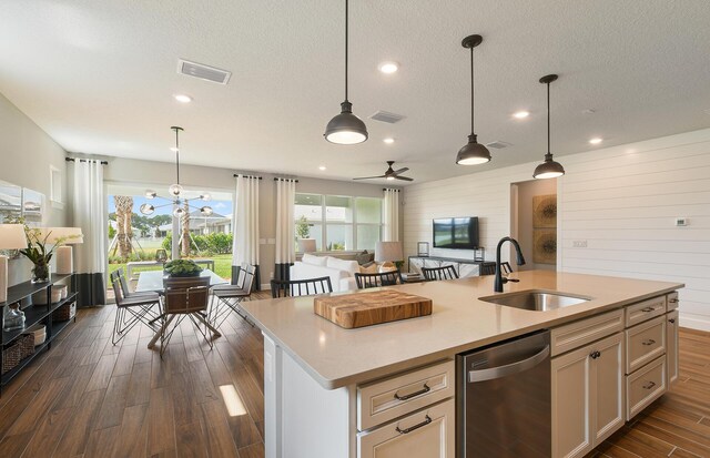 kitchen with pendant lighting, sink, stainless steel dishwasher, and a kitchen island with sink