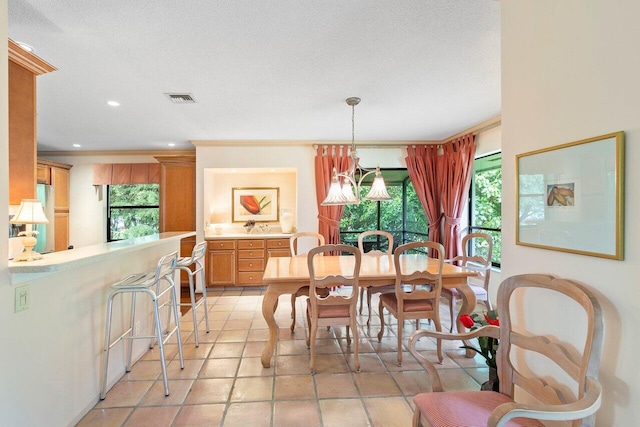 dining space with an inviting chandelier, a textured ceiling, and light tile patterned flooring