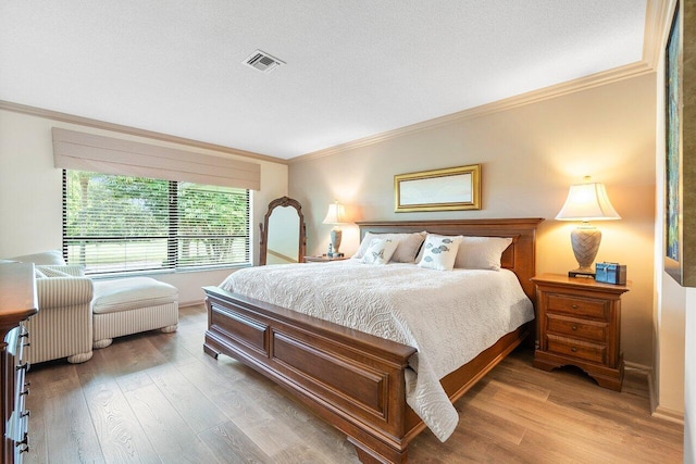 bedroom with crown molding and hardwood / wood-style floors