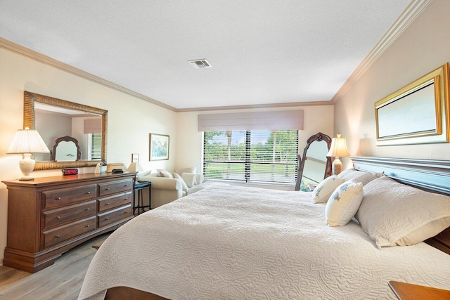 bedroom with crown molding and light hardwood / wood-style floors