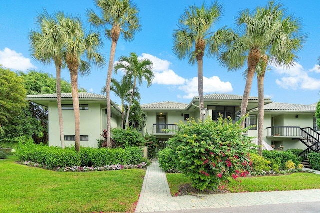 view of front of home with a balcony and a front yard