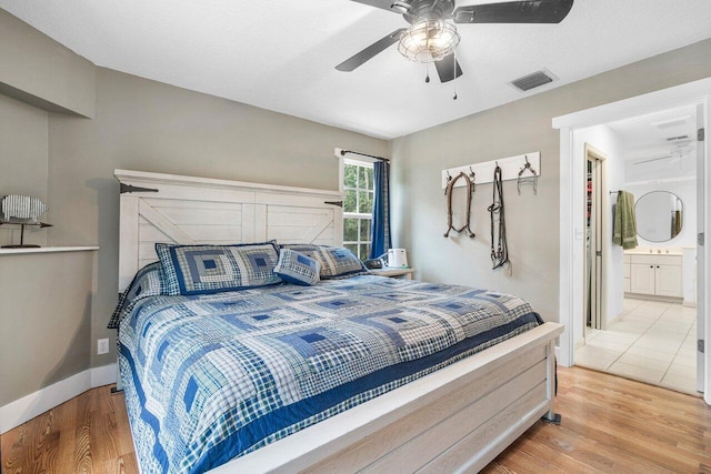 bedroom with ensuite bath, light wood-type flooring, and ceiling fan