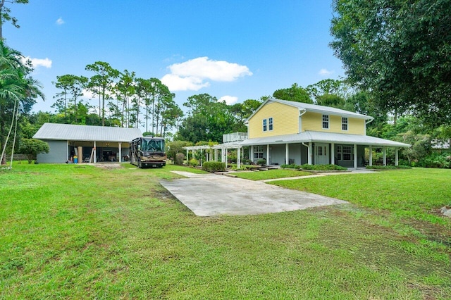 rear view of house featuring a lawn, covered porch, and a carport