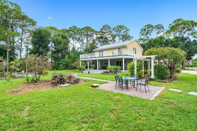 rear view of property featuring a patio, a fire pit, a balcony, a lawn, and a pergola