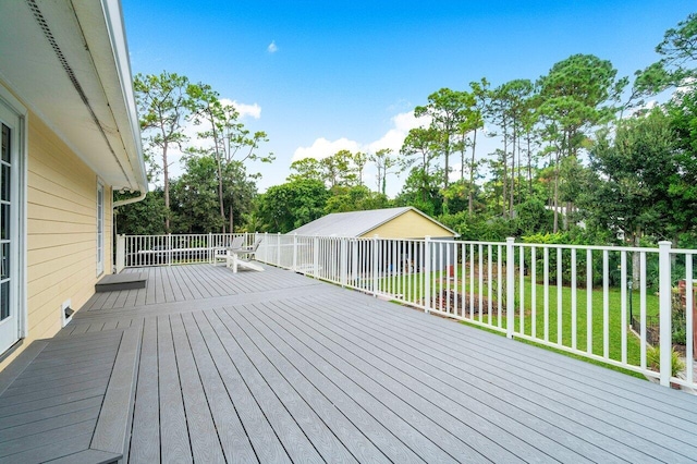 deck with a yard and an outdoor structure