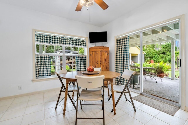 tiled dining space with ceiling fan and a wealth of natural light