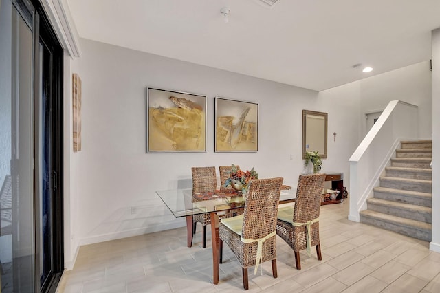 dining area with stairway, baseboards, and wood tiled floor