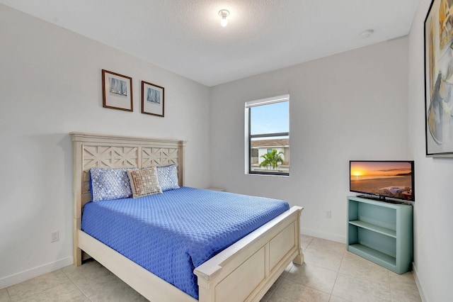 bedroom with light tile patterned floors and baseboards