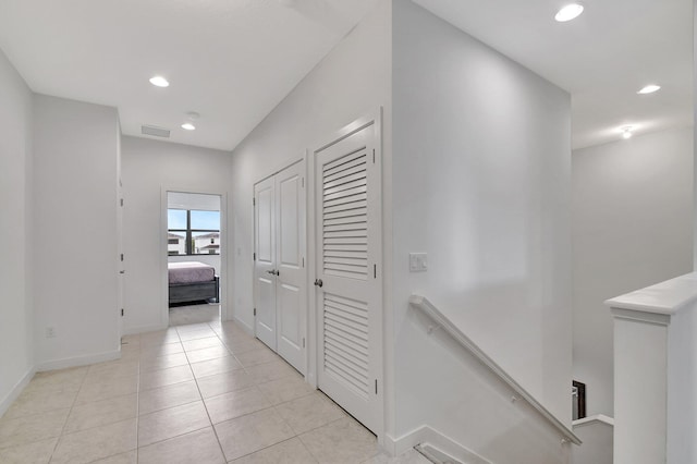 corridor with visible vents, baseboards, an upstairs landing, light tile patterned floors, and recessed lighting