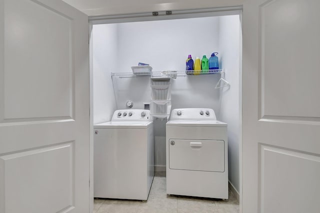 clothes washing area featuring light tile patterned flooring and independent washer and dryer