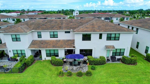 rear view of house with a patio, a yard, and an outdoor hangout area