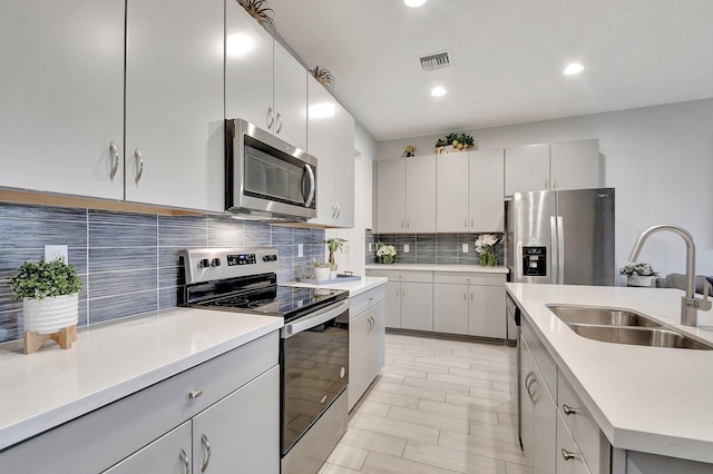 kitchen with stainless steel appliances, sink, and tasteful backsplash