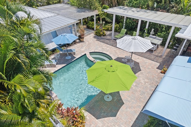 view of pool with an in ground hot tub, an outdoor living space, and a patio area