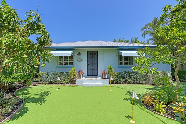 view of front facade with a standing seam roof, metal roof, and stucco siding