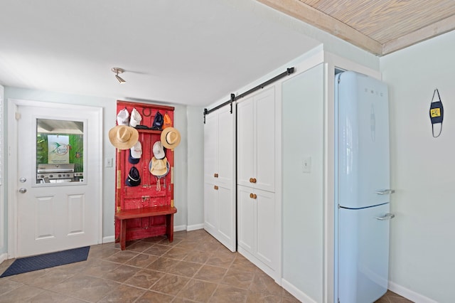 interior space with tile patterned flooring and a barn door