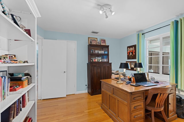 office with light wood-style flooring and visible vents