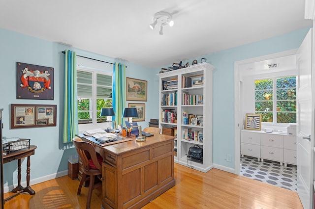 office featuring baseboards, visible vents, and light wood finished floors