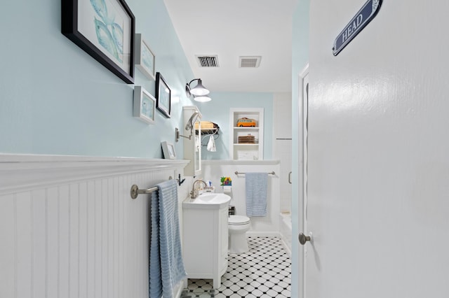 bathroom featuring toilet, a wainscoted wall, visible vents, and vanity