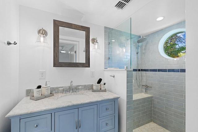 bathroom featuring a tile shower and vanity