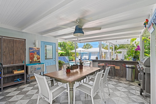 sunroom featuring ceiling fan, a wealth of natural light, and beamed ceiling