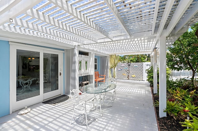 view of patio featuring outdoor dining space, fence, and a pergola