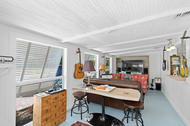 dining space with beam ceiling, visible vents, concrete floors, and baseboards