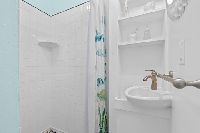 bathroom with a tile shower and a sink