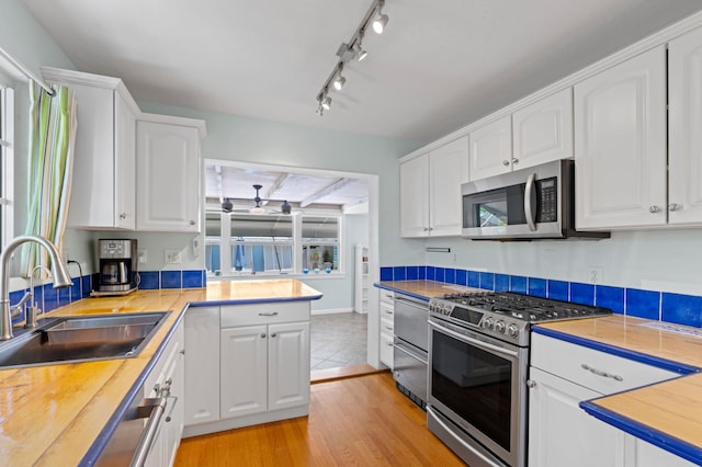 430 N Ocean Breeze, Lake Worth Beach, FL 33460 - kitchen with stainless steel appliances, white cabinets, and light wood-type flooring