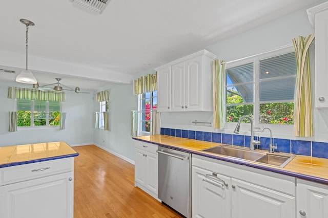 430 N Ocean Breeze, Lake Worth Beach, FL 33460 - kitchen with dishwasher, white cabinets, light wood-type flooring, decorative light fixtures, and beam ceiling