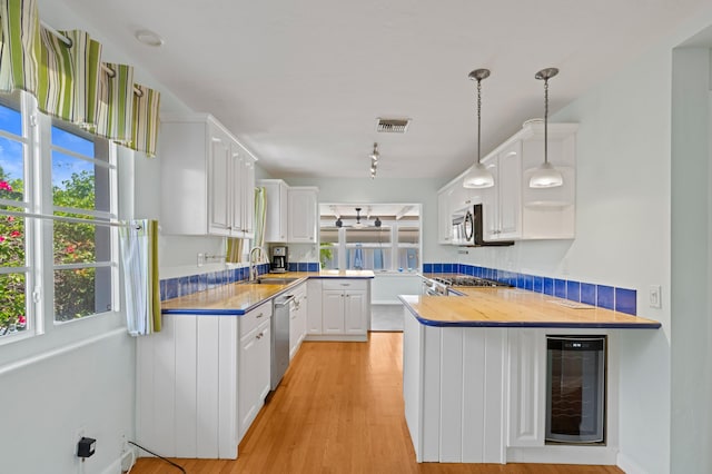 430 N Ocean Breeze, Lake Worth Beach, FL 33460 - kitchen featuring beverage cooler, a peninsula, and white cabinets