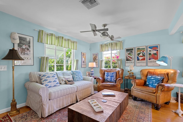 living room with baseboards, ceiling fan, visible vents, and wood finished floors