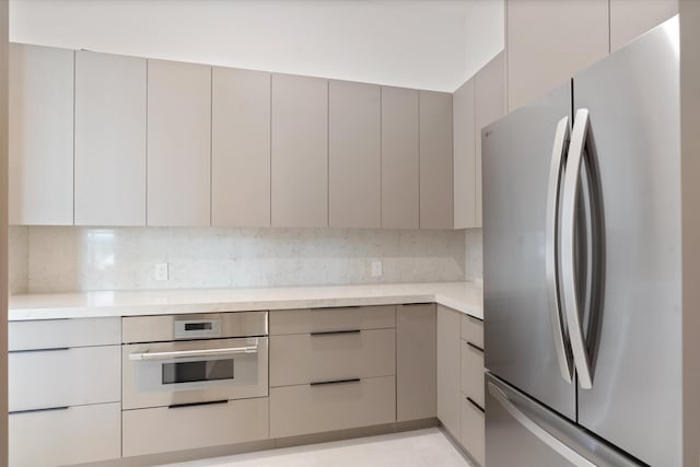 kitchen with stainless steel appliances, gray cabinets, and decorative backsplash